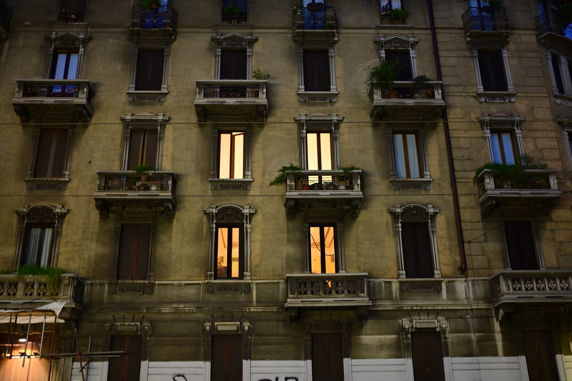 Warm windows of an apartment block at blue hour.