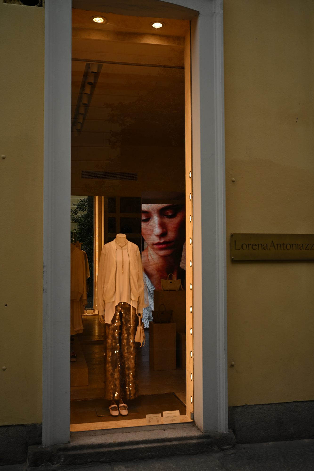 A figure glimpsed through a lit shop window.