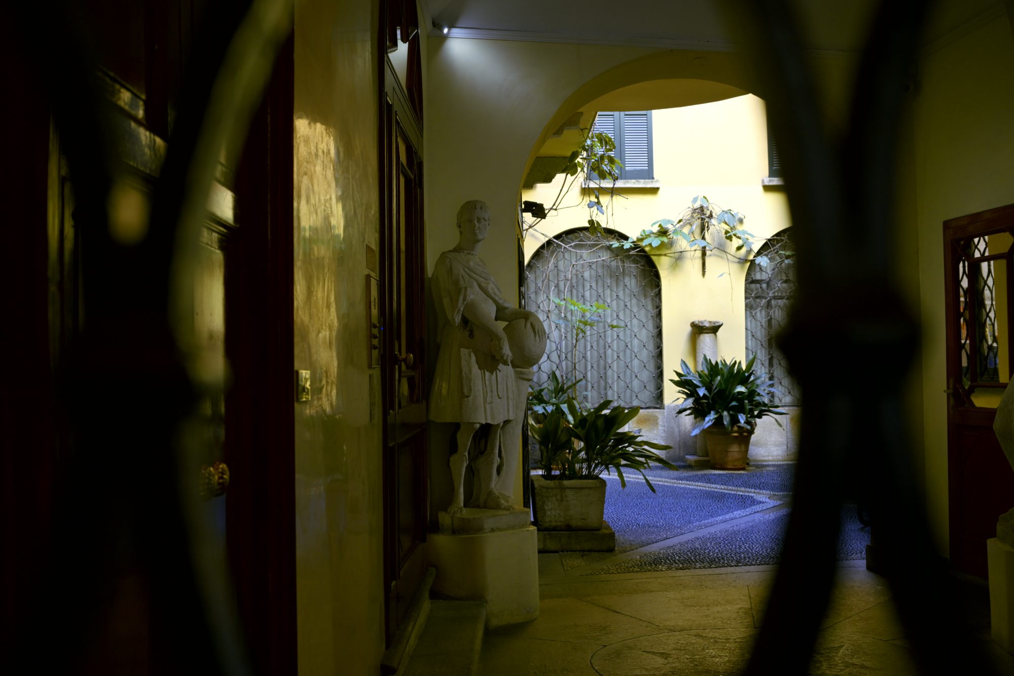 A stone soldier seen through a closed gate.